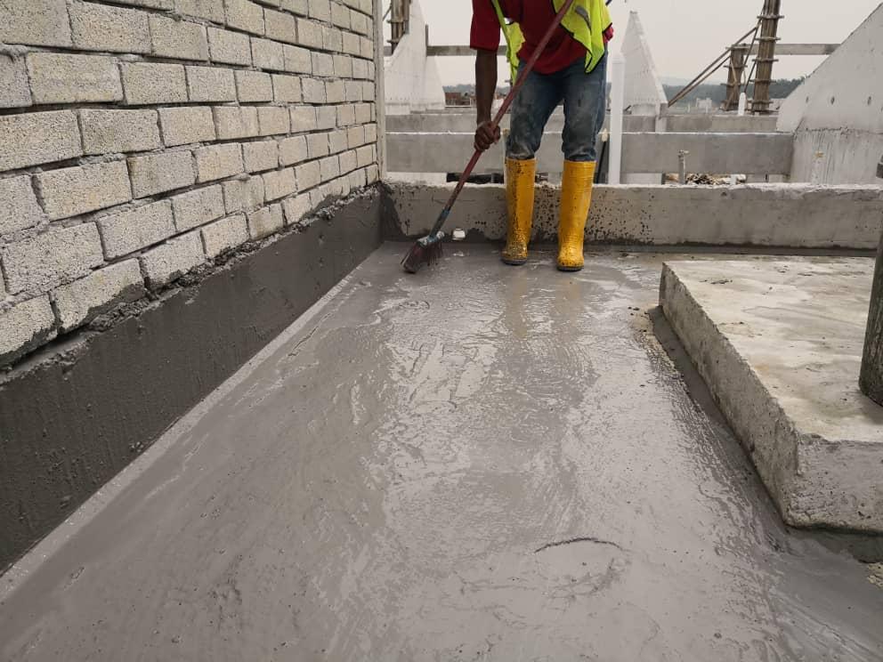 Cementitious waterproofing coating being applied to a concrete roof deck