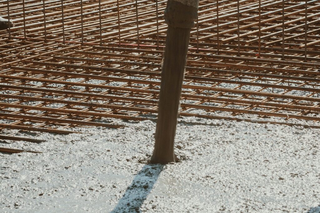 Close-up of spalled concrete column with exposed corroded reinforcement bar