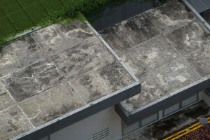 Worker applying liquid waterproofing membrane coating to a concrete roof deck in Qatar