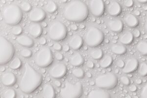 Wet bathroom floor tiles showing the surface that needs waterproofing before tiling